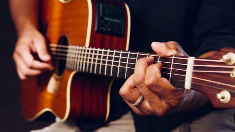 A close-up of a guitarist playing an acoustic guitar